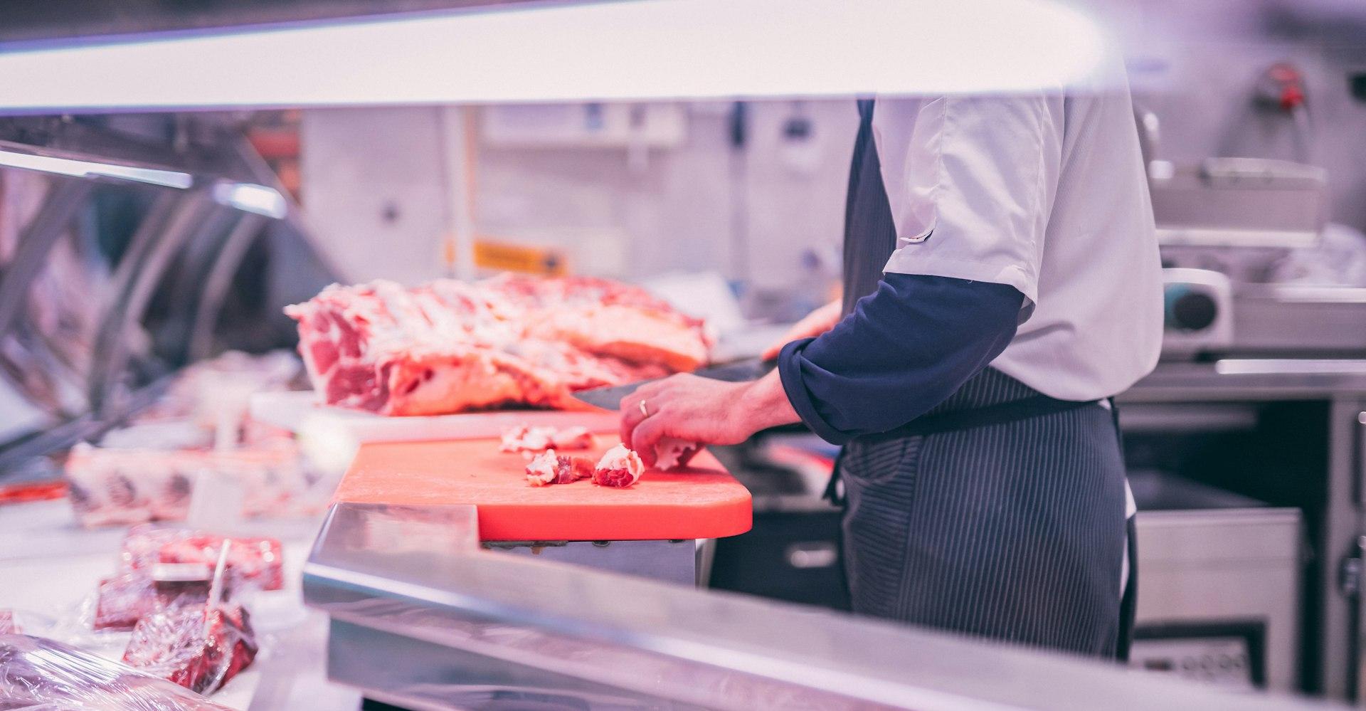 man slicing raw meat